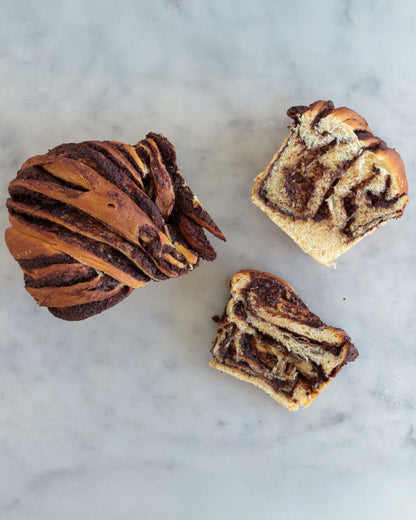 Baked chocolate babka, sliced to show the chocolate swirl